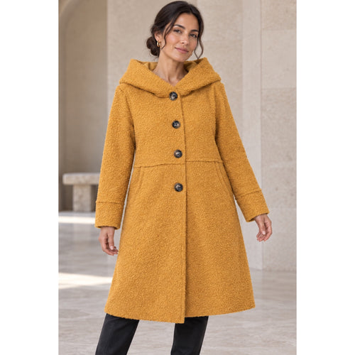 Modelo con abrigo mostaza de textura bouclé, cuello amplio y cierre de botones - POLITA 148299116.