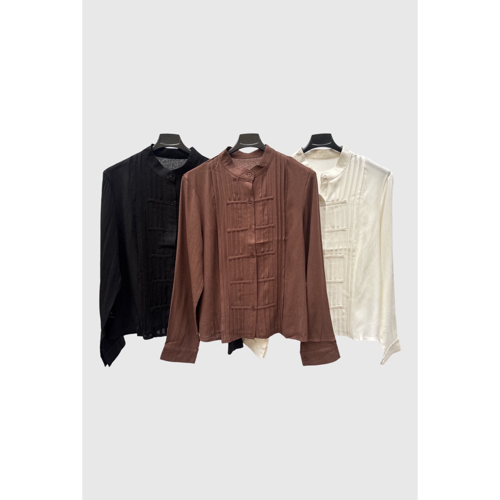 Blusas con cuello mao, alforzas verticales y tiras decorativas en negro, marrón y blanco.