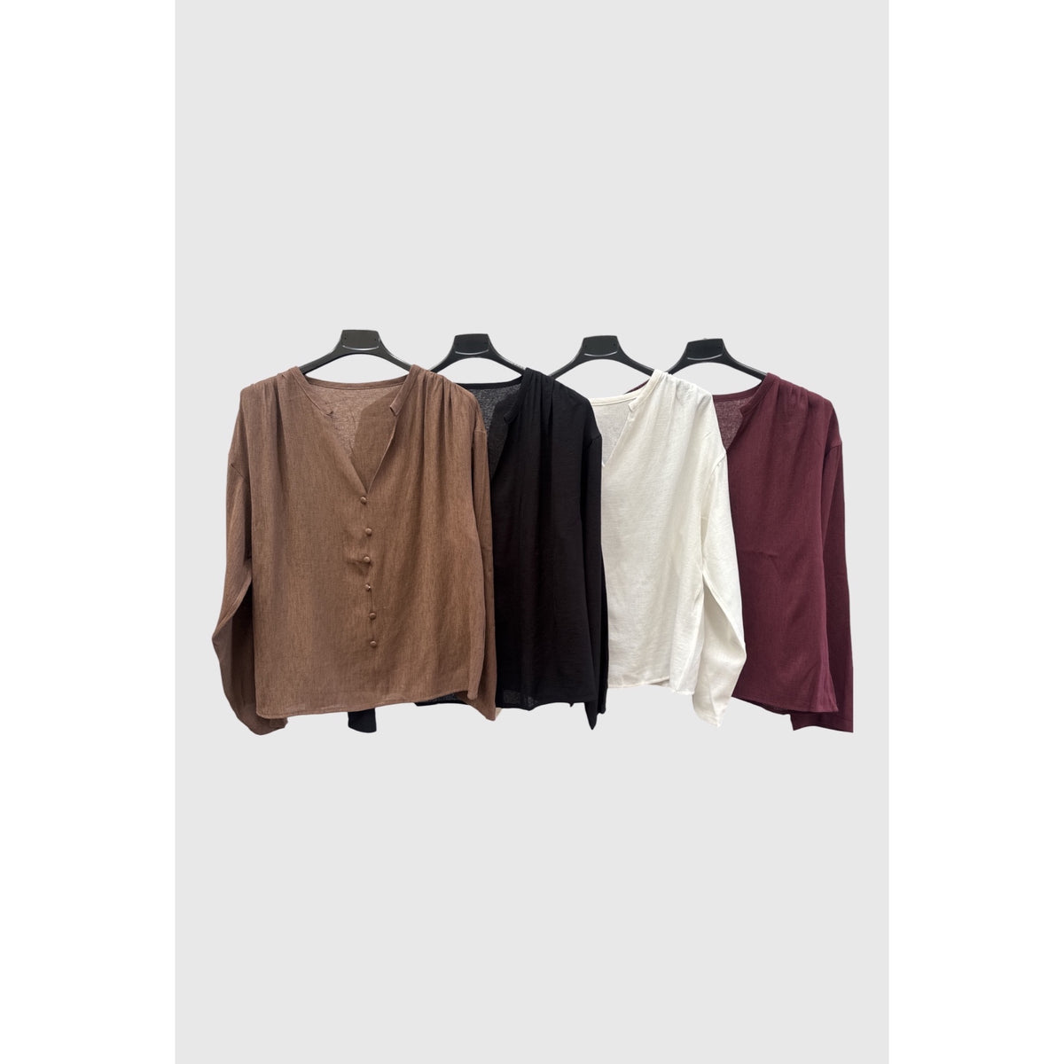 Blusas fluidas con escote en pico y botones al tono en marrón, negro, blanco y granate.