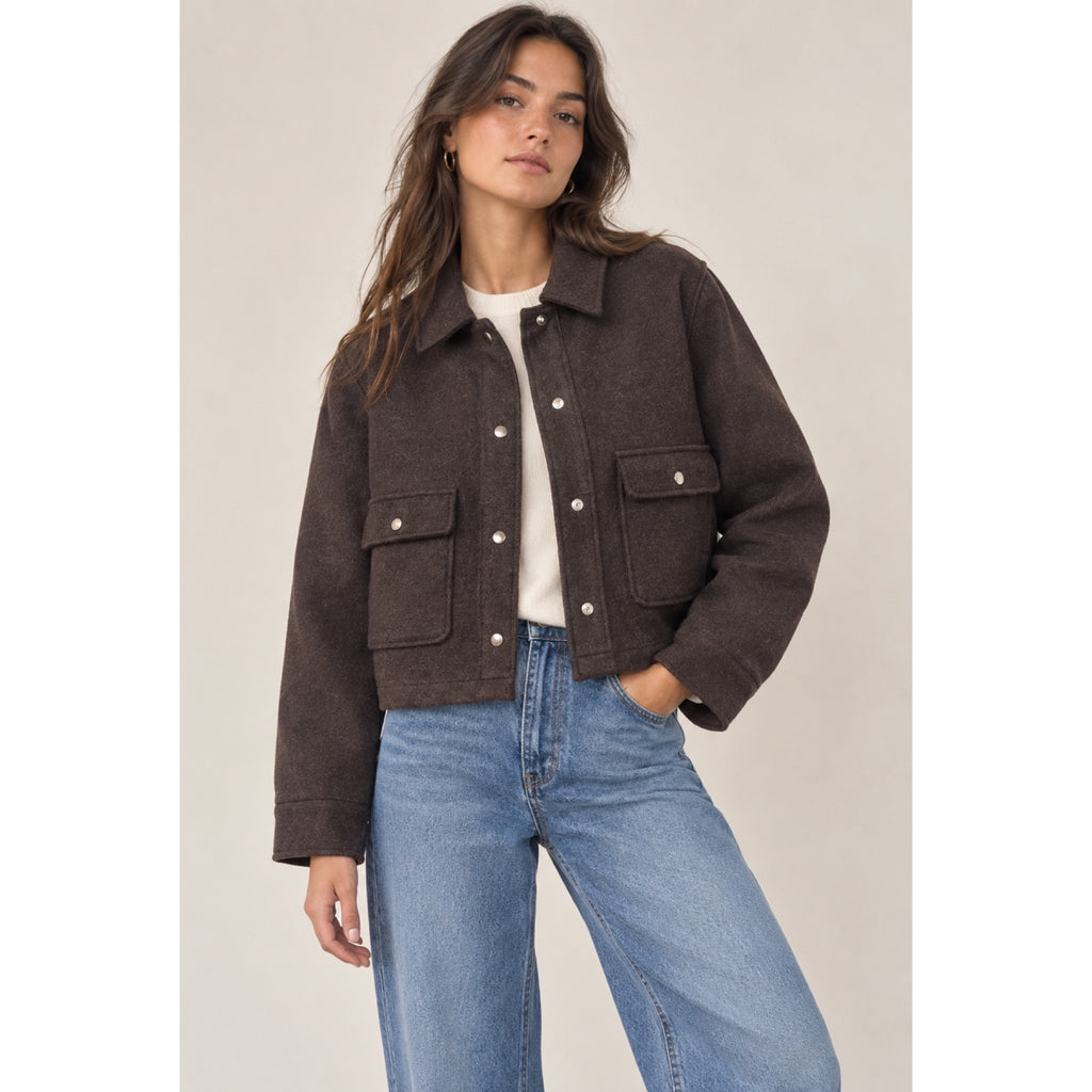 Modelo con chaqueta corta marrón, cuello camisero, botones a presión y bolsillos delanteros con solapa - POLITA 1414D1.