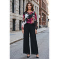 Modelo con conjunto de seda negro, blusa de flores fucsias, beige y blancas, mangas semitransparentes y pantalón palazzo.