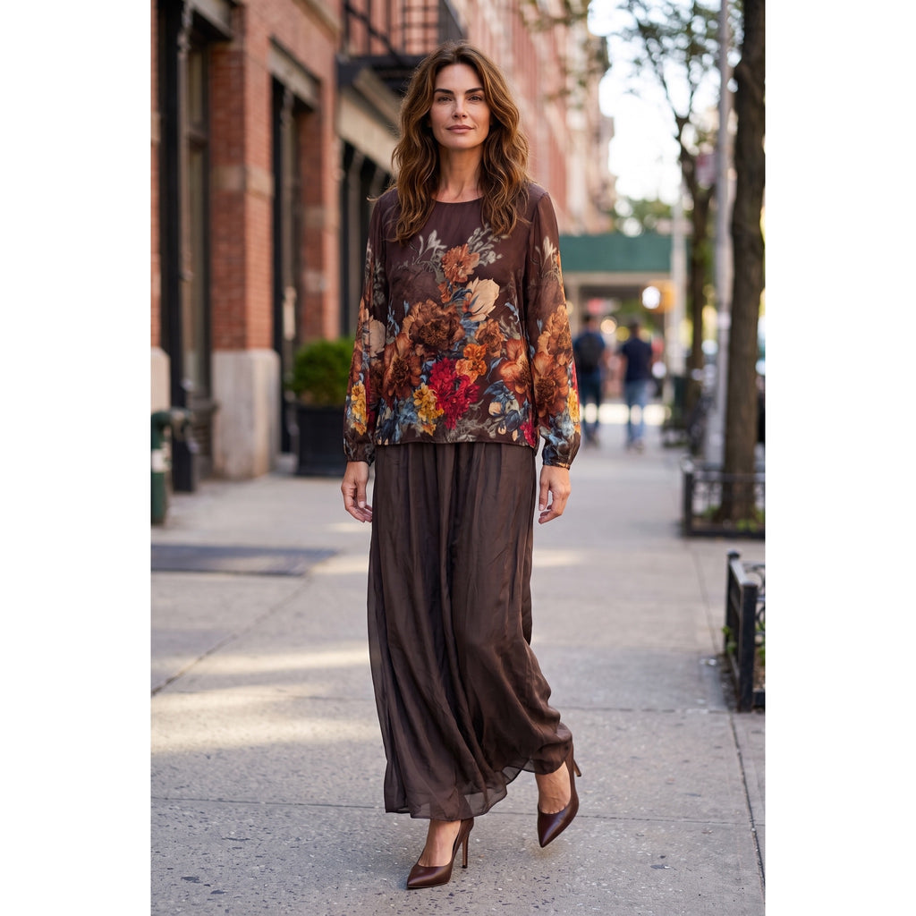 Modelo de frente con conjunto de seda choco, blusa de flores multicolor y pantalón palazzo liso coordinado.