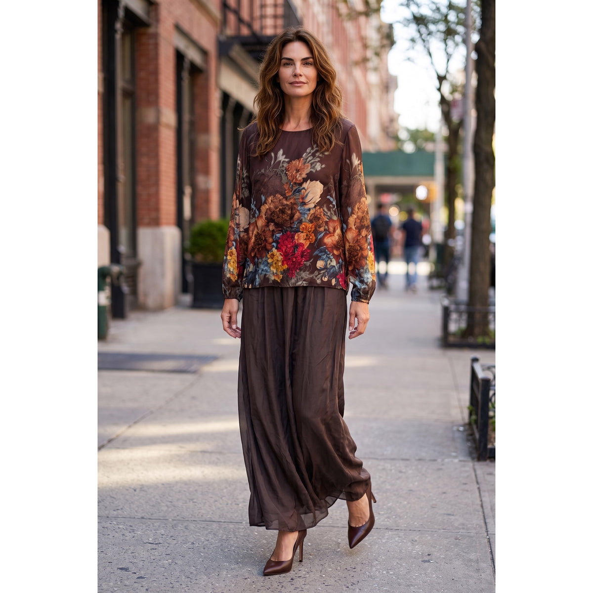 Modelo de frente con conjunto de seda choco, blusa de flores multicolor y pantalón palazzo liso coordinado.