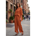 Conjunto de seda naranja con blusa de flores en relieve y pantalón ancho, llevado por una modelo - POLITA 1419C7234FL.