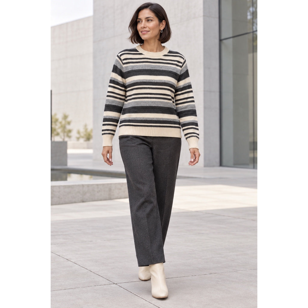 Modelo con jersey de rayas crema, gris y antracita, con cuello redondo y puños de canalé, combinado con pantalón gris.
