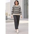Modelo con jersey de rayas crema, gris y antracita, con cuello redondo y puños de canalé, combinado con pantalón gris.