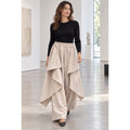 Modelo con pantalón efecto trench beige de pierna ancha, cintura elástica y paneles asimétricos superpuestos - POLITA 141468150.