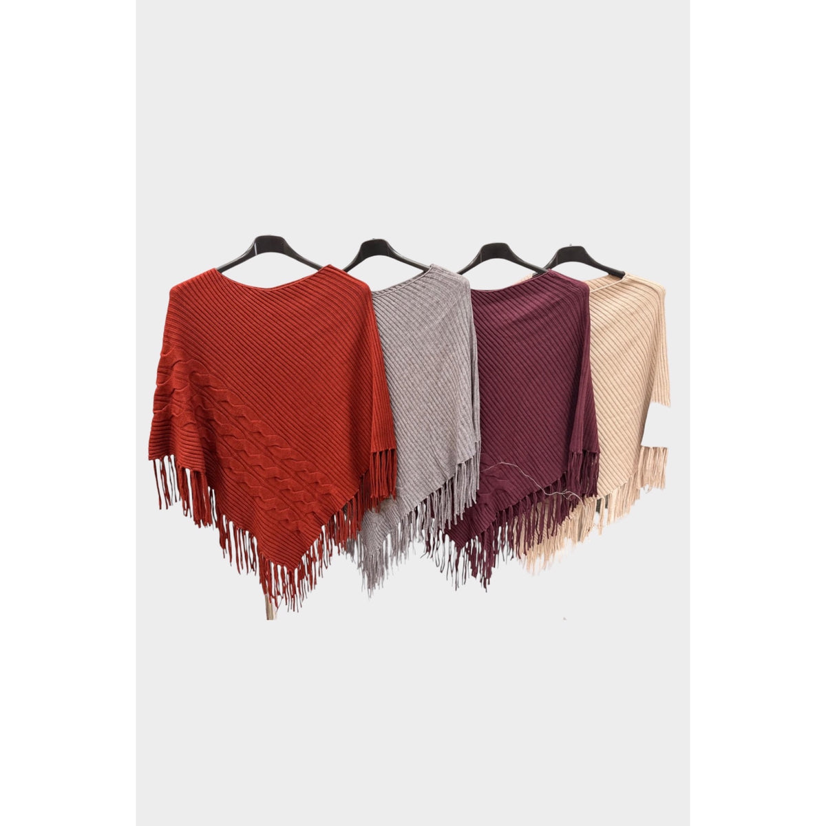 Ponchos de punto con trenzas y flecos en caldera, gris, granate y beige.